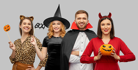 Image showing happy smiling friends in halloween costumes