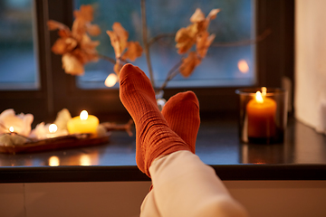 Image showing feet in socks on window sill at home in autumn