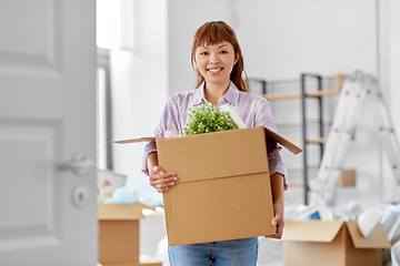 Image showing happy woman unpacking boxes and moving to new home