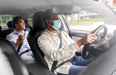 Image showing male driver in mask driving car with passenger