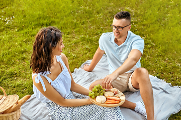 Image showing happy couple having picnic at summer park