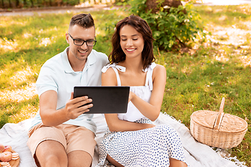 Image showing happy couple with tablet pc at picnic in park