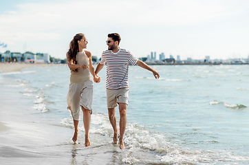 Image showing happy couple running along summer beach