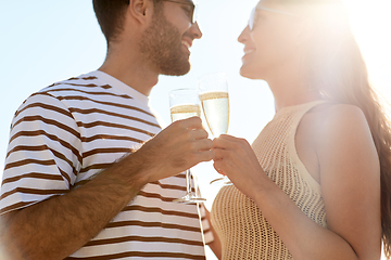 Image showing happy couple drinking champagne on summer beach