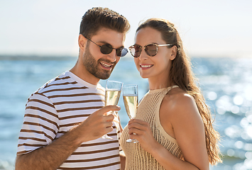 Image showing happy couple drinking champagne on summer beach