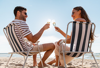 Image showing happy couple drinking champagne on summer beach