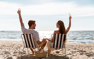 Image showing happy couple drinking champagne on summer beach