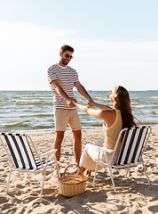 Image showing happy couple sitting in folding chairs on beach