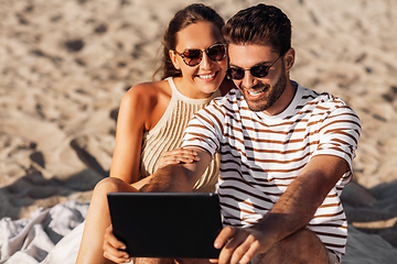 Image showing happy couple with tablet pc at on summer beach