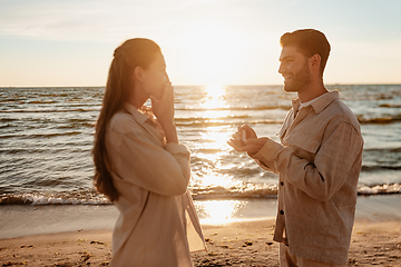 Image showing man with ring making proposal to woman on beach