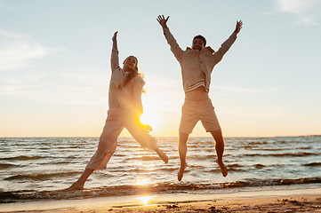 Image showing happy couple jumping on summer beach