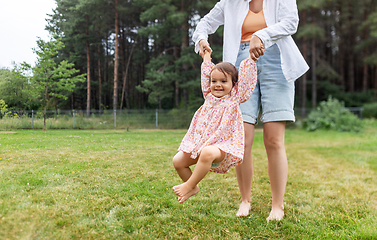 Image showing happy mother playing with baby daughter outdoors