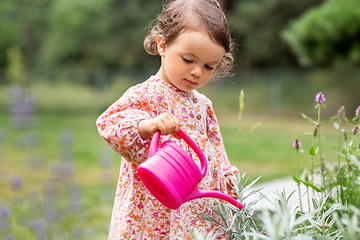 Image showing happy baby girl with watering can in summer garden