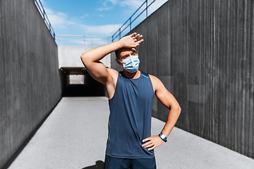 Image showing tired man in medical mask doing sports outdoors