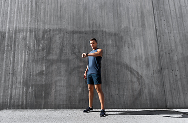 Image showing young man with fitness tracker on city street