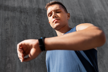 Image showing young man with fitness tracker on city street