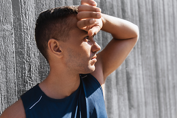 Image showing portrait of tired young man doing sports outdoors