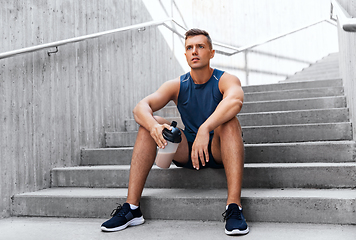 Image showing sportsman with shake in bottle sitting on stairs