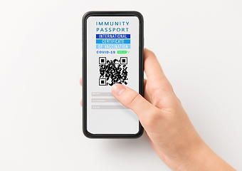 Image showing hand holding phone with certificate of vaccination