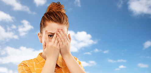 Image showing red haired teenage girl looking through fingers