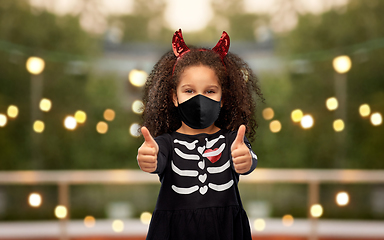 Image showing girl in black mask showing thumbs up on halloween