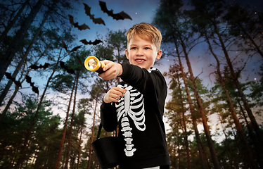 Image showing boy with candies and flashlight on halloween