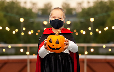 Image showing girl in halloween costume and mask with pumpkin