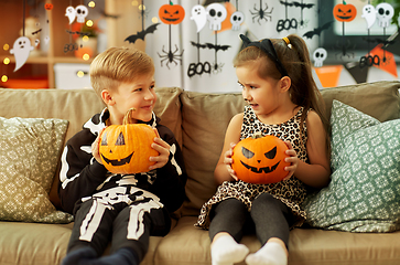 Image showing kids in halloween costumes with pumpkins at home