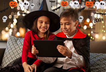Image showing kids in halloween costumes with tablet pc at home