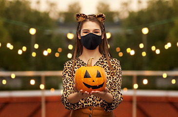 Image showing woman in halloween costume and mask with pumpkin