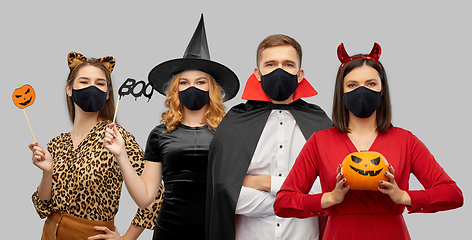 Image showing friends in halloween costumes and black masks