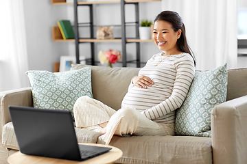 Image showing happy pregnant asian woman with laptop at home