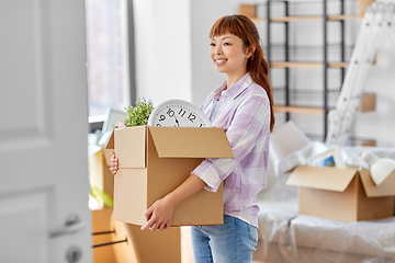 Image showing happy woman unpacking boxes and moving to new home