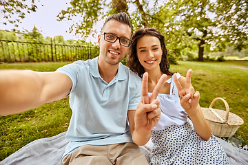 Image showing happy couple taking selfie at picnic in park