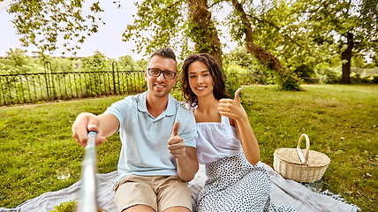 Image showing happy couple taking selfie at picnic in park