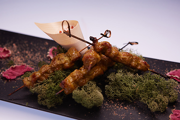 Image showing deep fried chicken tendons and sauce on white dish with wooden background
