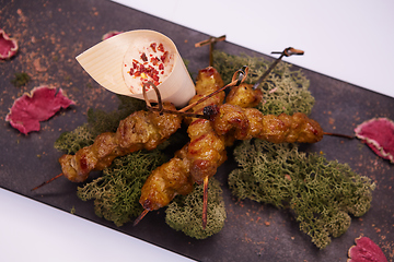 Image showing deep fried chicken tendons and sauce on white dish with wooden background
