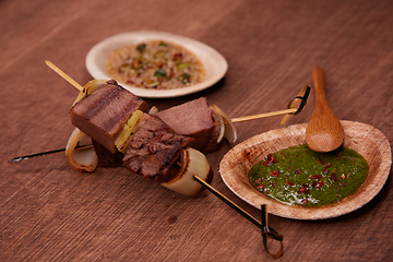 Image showing Grilled pork meat with sauce inserted with bamboo sticks. Shallow dof