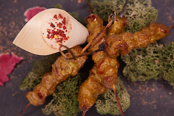 Image showing deep fried chicken tendons and sauce on white dish with wooden background