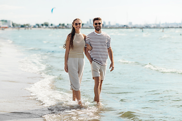 Image showing happy couple walking along summer beach