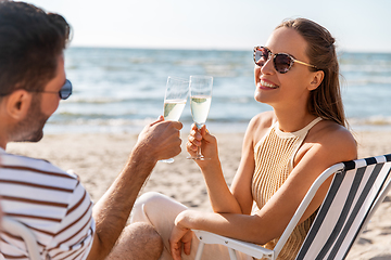 Image showing happy couple drinking champagne on summer beach