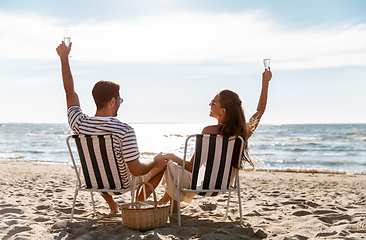 Image showing happy couple drinking champagne on summer beach