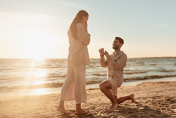 Image showing man with ring making proposal to woman on beach