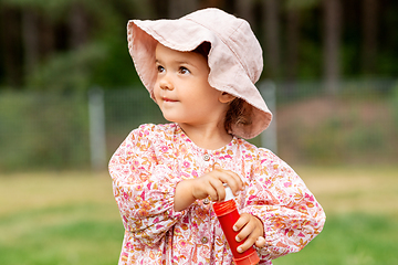 Image showing happy baby girl with soap bubble blower in summer