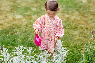 Image showing happy baby girl with watering can in summer garden