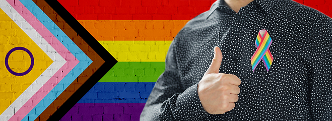 Image showing close up of man with gay pride ribbon shows thumb