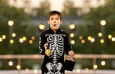 Image showing boy in halloween costume with candies and torch