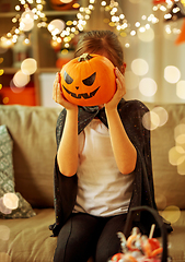 Image showing girl in halloween costume with pumpkin at home