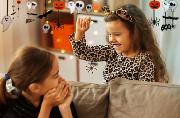 Image showing girls in halloween costumes playing with spider