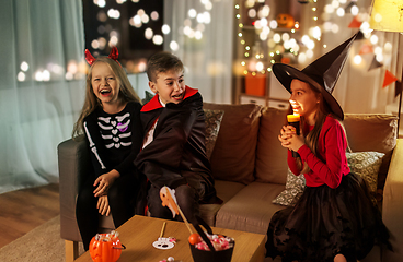 Image showing kids in halloween costumes playing at home